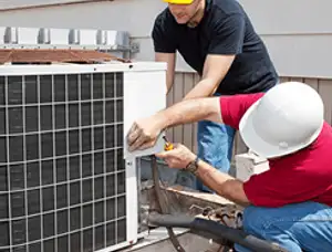 HVAC technicians repairing an outdoor AC unit on a rooftop in Plymouth, MA