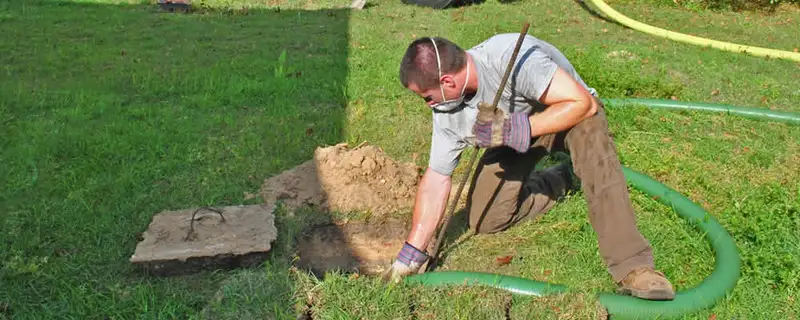Septic pumping technician servicing a residential septic tank in Plymouth, MA