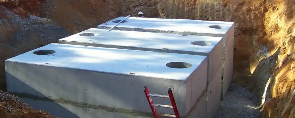 Septic tank installation site with a newly placed concrete tank in Plymouth, MA